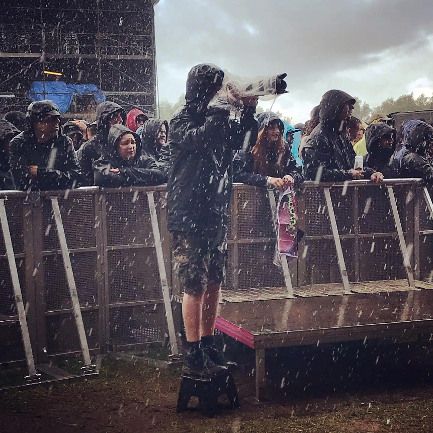 Steve Johnston at a festival in the rain. Crowd is behin him.